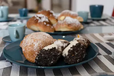 two plates of donuts and pastries on a table at Cassaro Casa Vacanze in Castellammare del Golfo