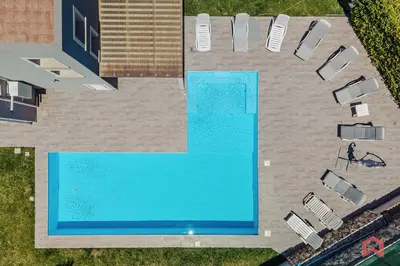 an overhead view of a swimming pool with chairs and a person at Nuova Villa a Scopello con piscina privata in Balata di Baida