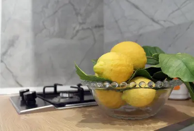 a glass bowl filled with lemons on top of a stove at Case Carà 128, Appartamentini nel cuore di Bagheria, Piano Primo in Bagheria
