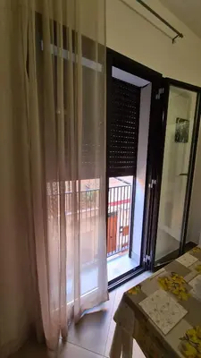 a room with a window with curtains and a table at Case Carà 128, Appartamentini nel cuore di Bagheria, Piano Primo in Bagheria