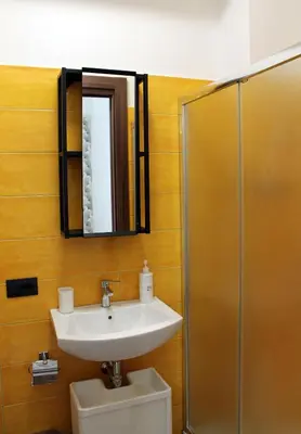 a bathroom with a sink and a mirror and a toilet at Case Carà 128, Appartamentini nel cuore di Bagheria, Piano Primo in Bagheria
