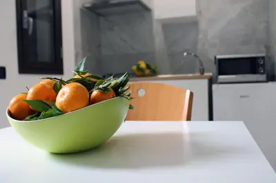 a bowl of oranges sitting on top of a table at Case Carà 128, Appartamentini nel cuore di Bagheria, Piano Primo in Bagheria
