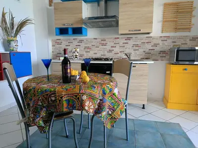 a kitchen with a table with a bottle of wine at Fronte Mare in Castellammare del Golfo