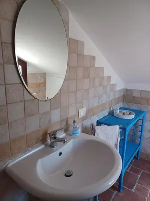 a bathroom with a white sink and a mirror at Mansarda Marina in Campofelice di Roccella