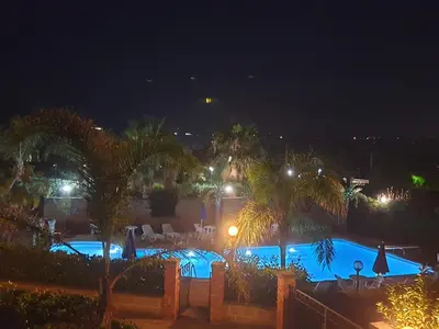 a view of a swimming pool at night at Mansarda Marina in Campofelice di Roccella