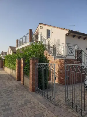 a brick building with a gate and a house at Mansarda Marina in Campofelice di Roccella