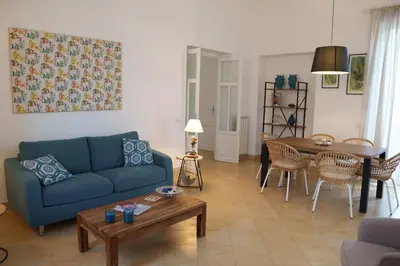 a living room with a blue couch and a table at Le Vele Mondello, villa a due passi dal mare in Mondello