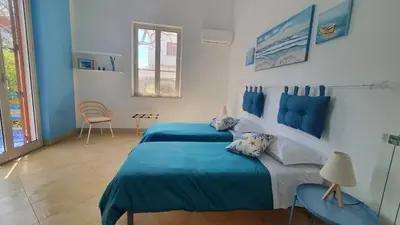 a bedroom with two beds with blue sheets at Le Vele Mondello, villa a due passi dal mare in Mondello