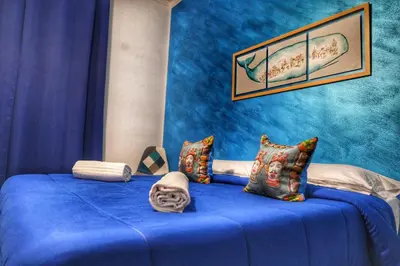 a room with a blue bed with pillows at La Casa del Moro - Al Politeama in Palermo