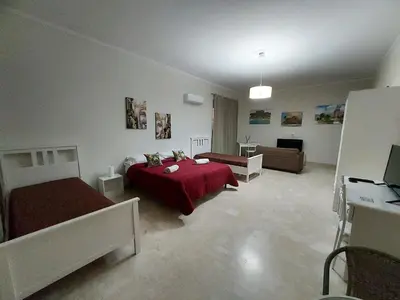 a bedroom with two beds and a living room at La Casa del Moro - Al Politeama in Palermo