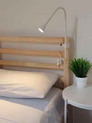 a bed with a lamp and a plant next to a table at Lovely Apartment in the City Centre in Palermo
