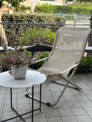 a white chair and a table with a potted plant at Villa Savoia Mondello in Mondello