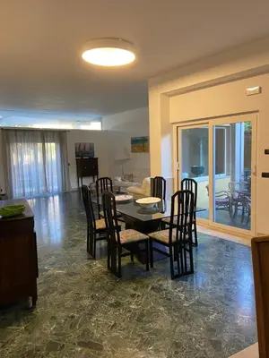 a dining room and living room with a table and chairs at Villa Savoia Mondello in Mondello