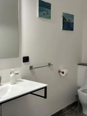 a white bathroom with a sink and a toilet at Villa Savoia Mondello in Mondello