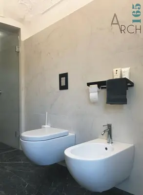 a bathroom with a white toilet and a sink at Le Camere dell’Emiro in Castronuovo di Sicilia
