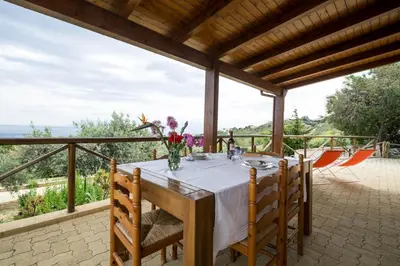 a table with a vase of flowers on a patio at VILLA BIFAMILIARE SCOPELLO in Scopello