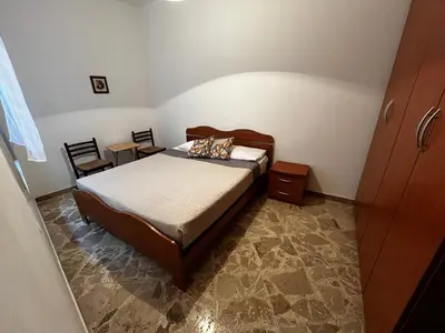a bedroom with a bed and two chairs in it at Casa Ciccio in San Vito lo Capo