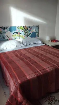 a bedroom with a large bed with a red blanket at Attico in centro città in Alcamo