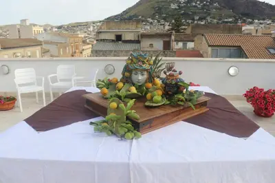 a plate of fruit with a statue on a table at Attico in centro città in Alcamo