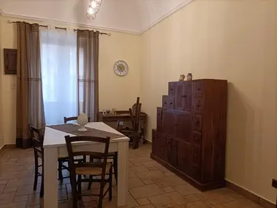 a dining room with a table and a wooden cabinet at La Sicilia in casa in Cinisi