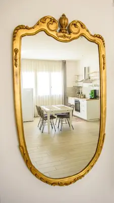 a mirror reflecting a dining room with a table and chairs at CENTRAL STATION APARTMENTS - Fanale Rentals in Palermo