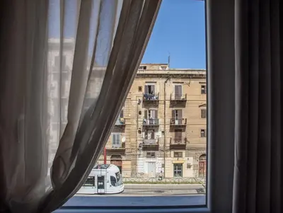 a window with a view of a building at CENTRAL STATION APARTMENTS - Fanale Rentals in Palermo