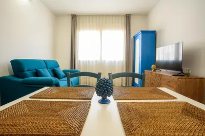 a living room with a table and a blue couch at CENTRAL STATION APARTMENTS - Fanale Rentals in Palermo
