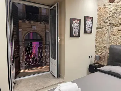a bedroom with a door to a balcony with skulls at Tommy's rooms in Palermo