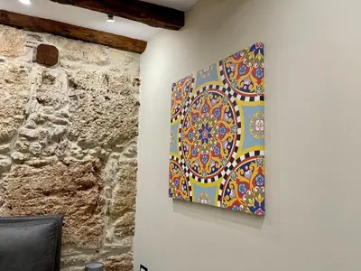 a painting hanging on a wall next to a stone wall at Tommy's rooms in Palermo