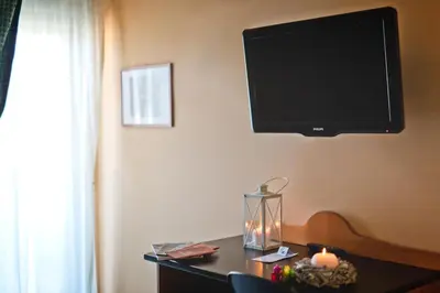 a flat screen tv hanging on a wall with a desk at Albergo Athenaeum in Palermo