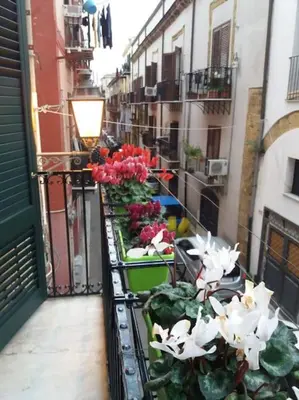 a balcony with flowers on the side of a building at Casa vacanza Sole di Sicilia in Palermo