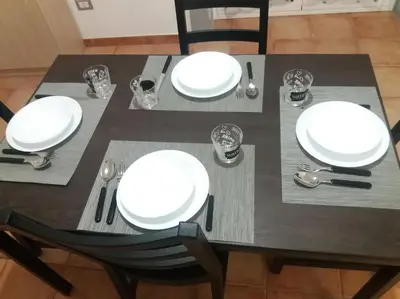 a dining table with white plates and silverware on it at Casa vacanza Sole di Sicilia in Palermo