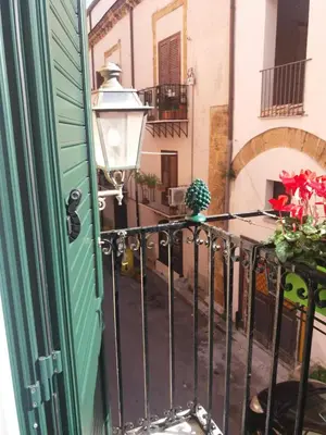 a balcony with a green door and a lamp at Casa vacanza Sole di Sicilia in Palermo