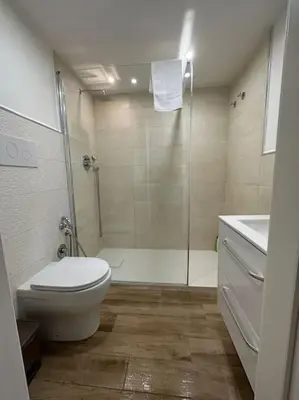 a bathroom with a shower and a toilet and a sink at Cusciulìu House in Palermo