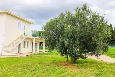 a tree in front of a house at Cà del Re Holiday in Partinico