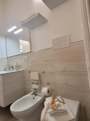 a bathroom with a sink and a toilet and a mirror at JEY STUDIO_INDEPENDENT SEAFRONT APARTMENT in Terrasini