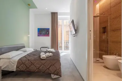 a bedroom with a bed and a bathroom with a tub at Mag 179 Bed & Spa in Palermo