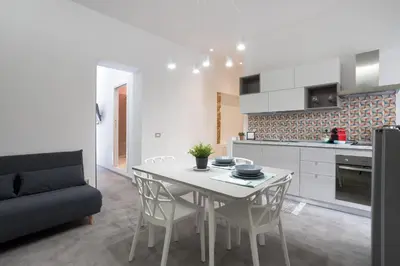 a kitchen and dining room with a white table and chairs at Mag 179 Bed & Spa in Palermo