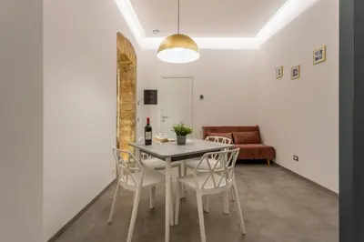 a dining room with a table and chairs and a couch at Mag 179 Bed & Spa in Palermo