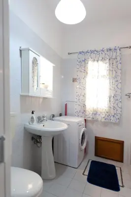 a white bathroom with a sink and a toilet at Confortevole appartamentino in Castellammare del Golfo
