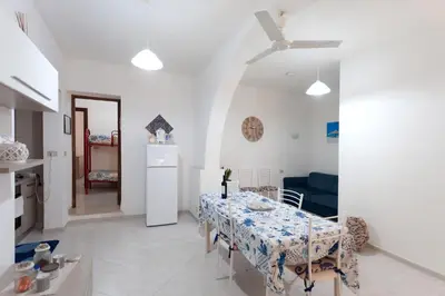 a kitchen and a dining room with a table and chairs at Confortevole appartamentino in Castellammare del Golfo