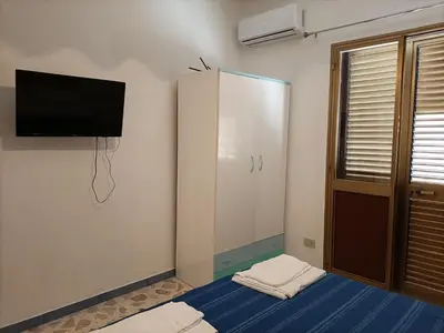 a room with a tv on the wall and a bed at La casetta a Scopello in Scopello