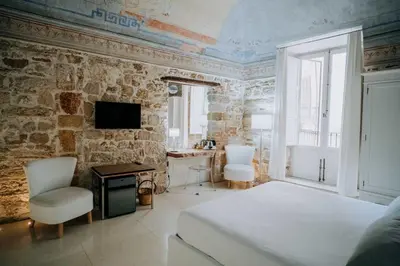 a bedroom with a bed and a desk and a tv at Ambrosia-Timeless Hosting in Palermo
