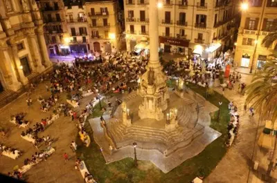 a large crowd of people standing around a fountain in a city at IGIEA ROOMS in Palermo