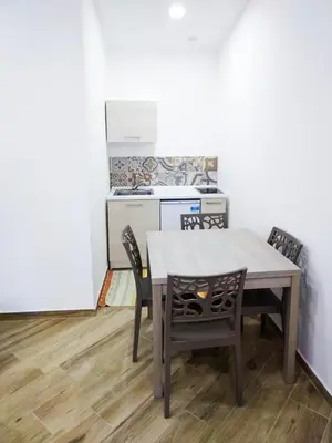 a kitchen with a table and chairs in a room at IGIEA ROOMS in Palermo