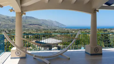 a hammock on a balcony with a view of the ocean at VILLA OLIMPIA 6&2, Emma Villas in Castellammare del Golfo