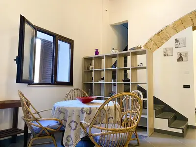 a dining room with a table and chairs at Scopello Home in Castellammare del Golfo