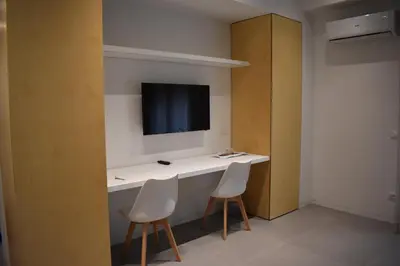 a room with a desk with two chairs and a tv at GiaChi friendly studios a Ballarò in Palermo