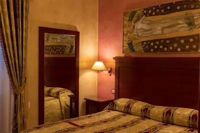 a hotel room with a bed and a mirror at Hotel Joli in Palermo