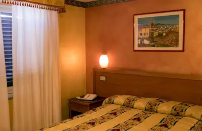 a bedroom with a bed and a phone on a table at Hotel Joli in Palermo